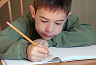 first grade boy writing on a worksheet