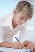 6th grade student writing at desk