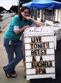 Girl standing next to sign with misspelled ukelele and more