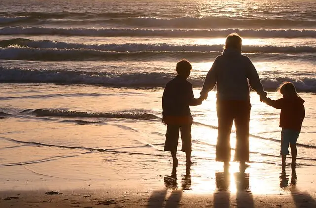 family walking at sunset on beach