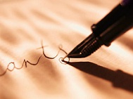 pointed ink pen writing in cursive on paper