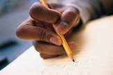 hand of a student writing on paper with a pencil