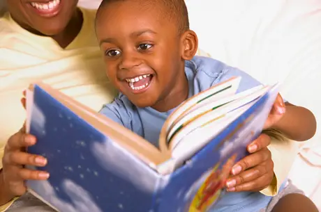 little boy on mom's lap enjoying a picture book