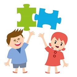 Two smiling students holding up jigsaw puzzle pieces