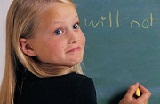 second grade girl writing "Will Not" on the chalkboard