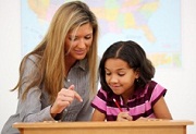 teacher and student working at student's desk