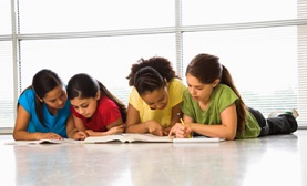 girls laying on the floor studying together