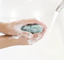 Hands washing with soap and water under a faucet